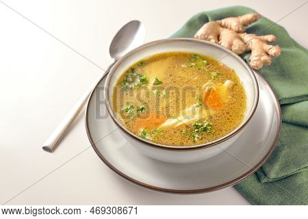 Homemade Chicken Soup With Vegetables, Ginger And Parsley In A Bowl, Green Napkin And Spoon On A Gay