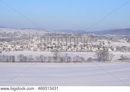 Snow Covered Eifel With Village Thür And Mendig Behind The Hill