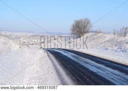 Mountain Road With Some Snow On The Asphalt After Removal