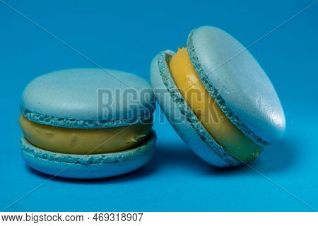 Two Blue Makaruns On A Blue Background. Air Dessert With Blueberries