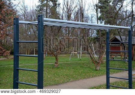 Outdoor Sports Field. Exercise Equipment With Gymnastic Rings To Strengthen The Arms. Bench For Trai