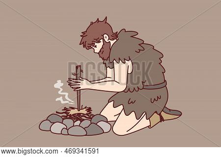 Primitive Man On Knees Near Stones For First Time Breeds Bonfire Using Stick And Friction Force. Anc