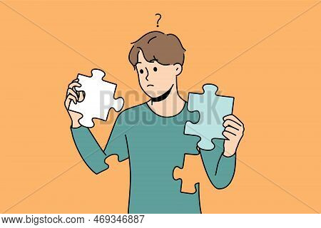 Frustrated Young Man With Jigsaw Puzzles In Hands Rebuild Personality. Concept Of Mental And Psychol