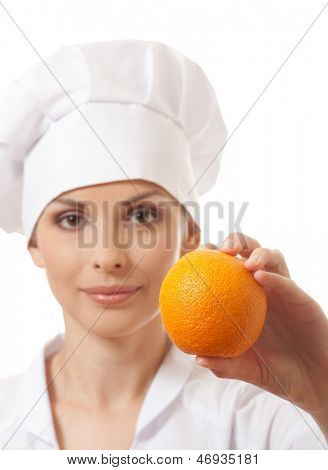 Smilende kvinde cook med orange, isoladed på hvid baggrund