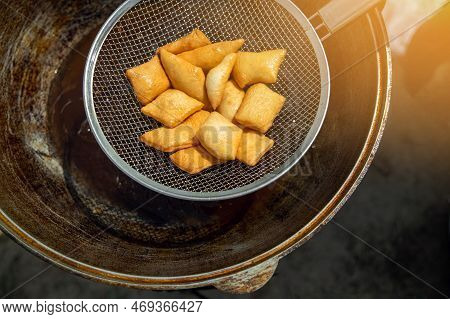 Traditional Kazakh And Central Asian Fresh Baursaks Are Taken Out Of A Large Cauldron With A Colande