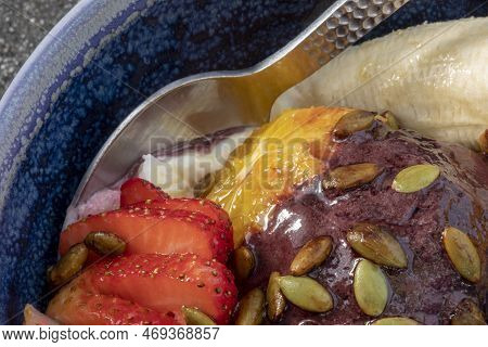 Closeup View Of The Acai Bowl In The Blue Plate With The Spoon