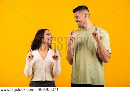 Cheerful Glad Millennial Middle Eastern Man And Woman Crossed Fingers Make A Wish, Believe In Miracl