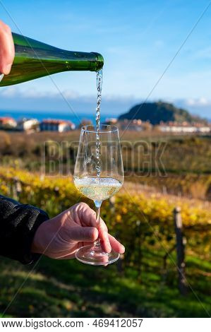 Pouring Of Txakoli Or Chacolí Slightly Sparkling Very Dry White Wine Produced In Spanish Basque Coun