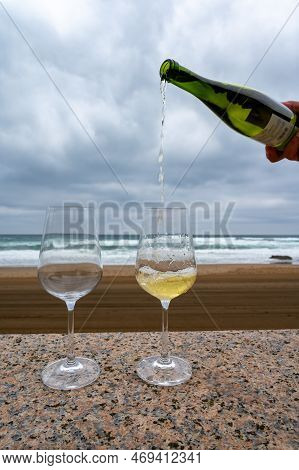 Pouring Of Txakoli Or Chacolí Slightly Sparkling Very Dry White Wine Produced In Spanish Basque Coun