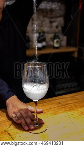 Pouring Of Txakoli Or Chacolí Slightly Sparkling Very Dry White Wine Produced In Spanish Basque Coun