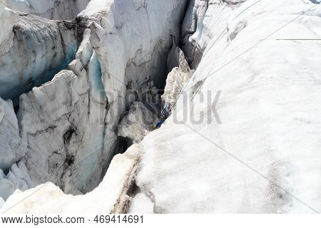 Man Is Ice Climbing In A Crevasse Of Glacier Pasterze At Icefall Hufeisenbruch In Glockner Group, Au