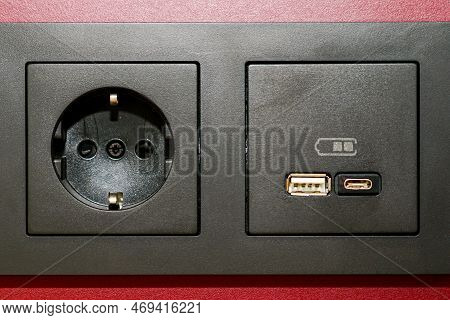 A Black 220v, Usb And Usb C Type Socket Block Is Built Into The Wall Surface