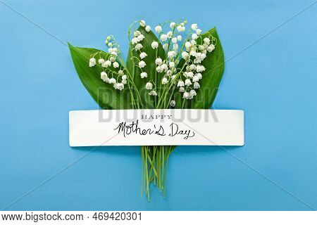 Mother's Day Background, Composition Of Spring Lilies Of The Valley Flowers On Blue Paper With Inscr
