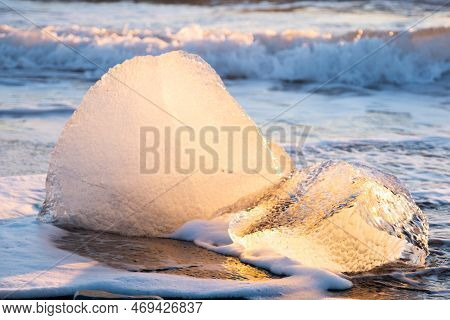Diamond Beach In Iceland. Icebergs Shining On Black Volcanic Sand. Clear Ice Crashed By Ocean Waves.