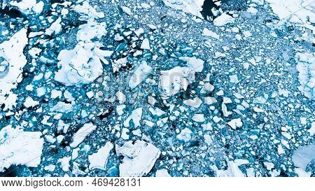 Melting Arctic Ice In Ocean Water. Blue Glacier Ice Covered With Snow In Iceland. Climate Crisis