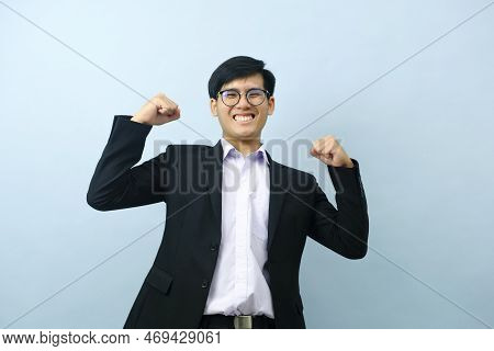 Portriat Of Asian Young Smart Happy Businessman Wearing Glasses And Dressed In Suit Standing Smiling