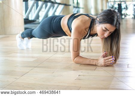 Young Woman Doing Plank Exercise During Workout In The Gym.