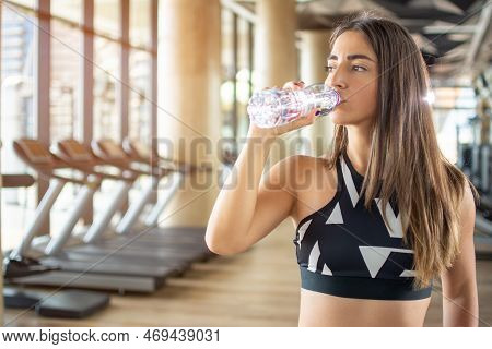 Beautiful Young Fit Woman Drinking Water After Training At Gym.