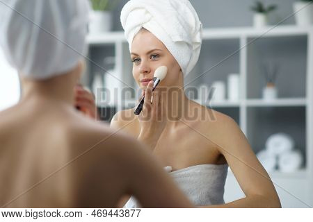 Young Woman Sits In The Bathroom In Front Of The Makeup Mirror And Does Cosmetic Procedures. Beautif