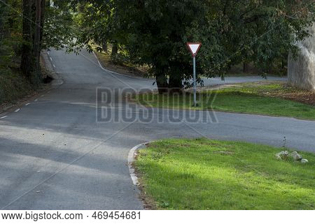 Give Way Sign Without Stopping At Dangerous Junction With Corrugated Asphalt In The Middle Of The Fo