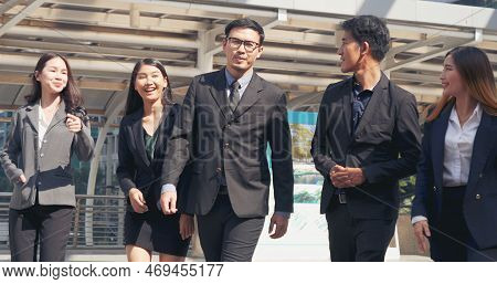 Group Of Business People Asian Team Partners Walking In City Happy Together. Leader Executive Men St