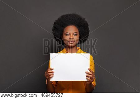 Young Confedent Woman Holds White Empty Paper Banner In Her Hand On Black Background