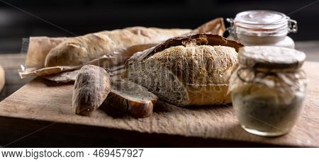Rye Sourdough Ripened In A Jar Together With Fresh Bread On A Cutting Board.