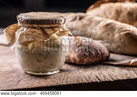 Rye Sourdough Ripened In A Jar Together With Fresh Bread On A Cutting Board.