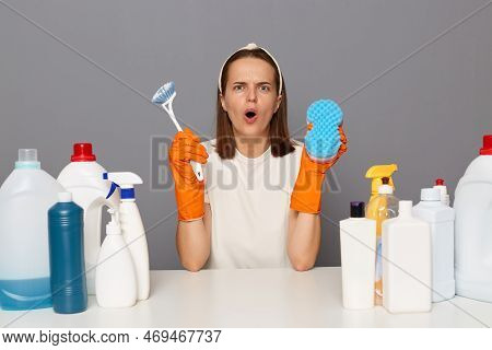 Image Of Shocked Astonished Woman In White T-shirt And Orange Gloves, Holding Brush And Sponger For 