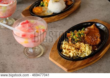 Close-up Of A Bowl Of Soba Noodles With Sliced Roast Beef Steak And Ice Fruit. Delicious Asian Cuisi