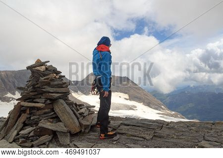 Mountaineer (man) Standing Next To Cairn On Summit Of Eiswandbichl And Looking At Mountain Snow And 