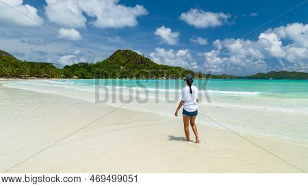 Young Woman At A White Tropical Beach Anse Volbert Beach Praslin Seychelles Islands.