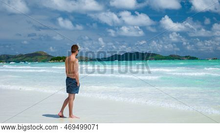 Young Men In Swim Short At A White Tropical Beach Anse Volbert Beach Praslin Seychelles