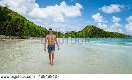 Young Tanning Men In Swim Short At A White Tropical Beach Anse Volbert Beach Praslin Seychelles