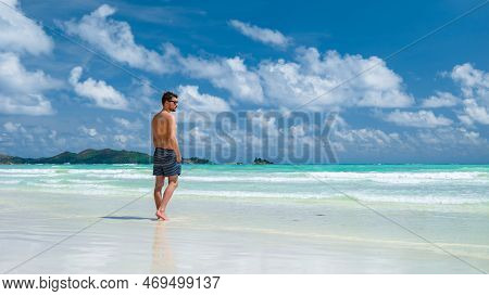 Young Man In Swim Short At A White Tropical Beach Anse Volbert Beach Praslin Seychelles