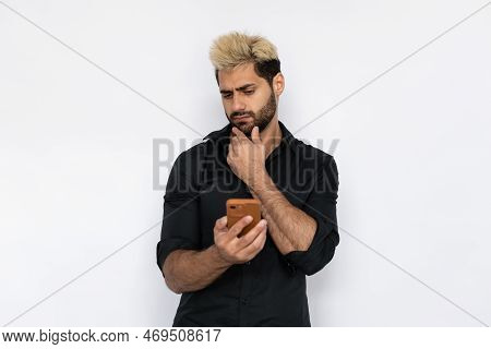 Hesitated Young Man Reading News On Smartphone. Male Caucasian Model With Brown Eyes, Ombre Painted 