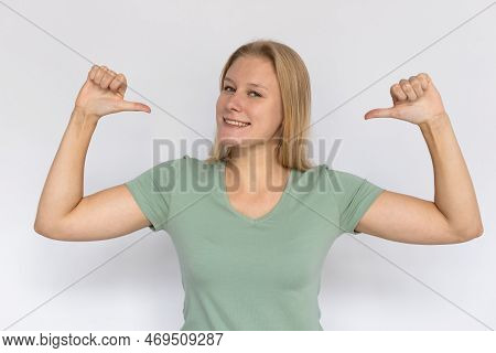 Happy Young Woman Pointing Thumbs At Herself. Portrait Of Proud Caucasian Female Model With Fair Hai