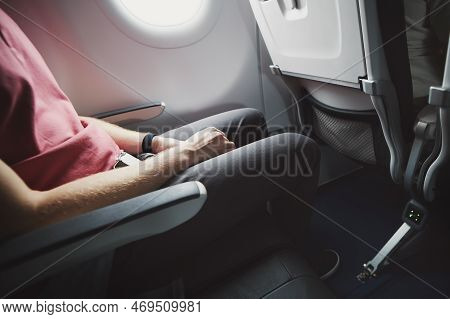 Man Resting During Flight. Legroom Between Seats In Commercial Airplane.