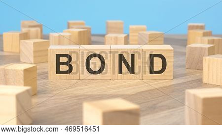 Bond - Word Is Written On Wooden Cubes Close-up. Bright Blue Background, Financial Business Concept