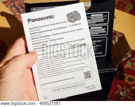 Paris, France - Dec 2, 2022: Male Hand Holding Operating Instruction Flyer Paper During The Unboxing