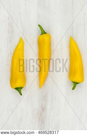 Yellow Sweet Pepper Ramiro Is Lying On A White Wooden Table