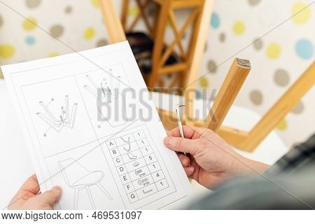 Self-assembly Furniture Concept. The Young Man Himself Assembling Chairs