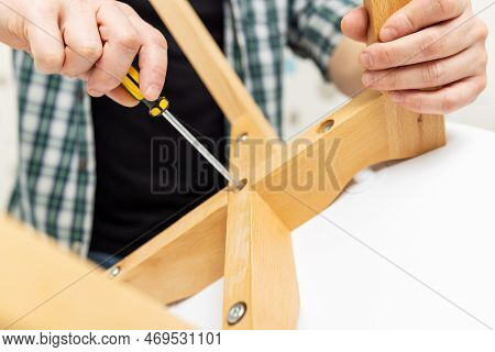 Self-assembly Furniture Concept. The Young Man Himself Assembling Chairs