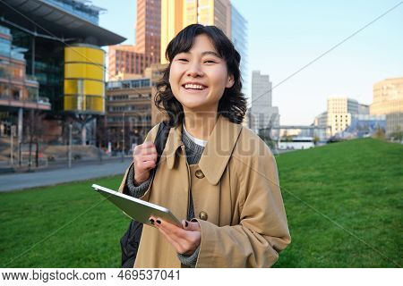Happy Young Brunette Girl, Asian Woman Walks Around City With Tablet, Goes To University With Her Di