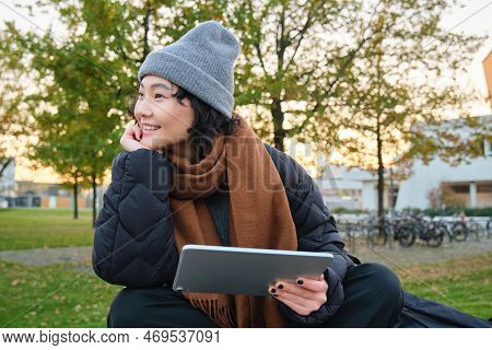 Smiling Asian Girl, Student Sits On Bench In Park Alone, Reading, Using Social Media App On Digital 