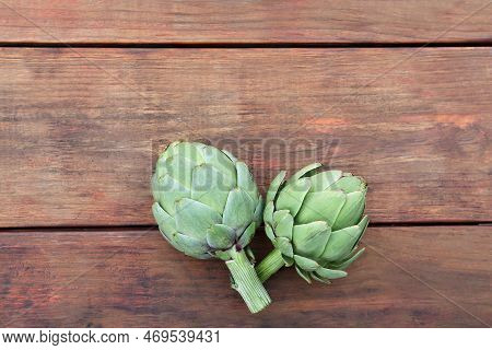 Fresh Raw Artichokes On Wooden Table, Flat Lay