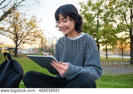 Portrait Of Young Smiling Korean Girl, Graphic Designer, Artist Drawing On Digital Tablet With A Pen