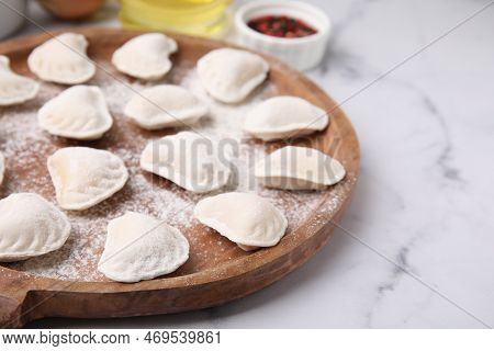 Raw Dumplings (varenyky) With Tasty Filling And Flour On White Marble Table, Closeup