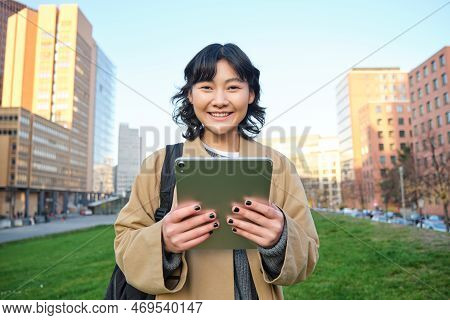Happy Young Brunette Girl, Asian Woman Walks Around City With Tablet, Goes To University With Her Di