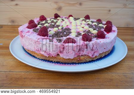 Rasperry Cake With Cream And White Chocolate On Wooden Board